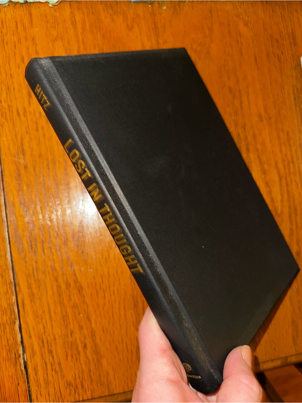 Black Hardcover Book "Lost in Thought" with Gold Spine Text